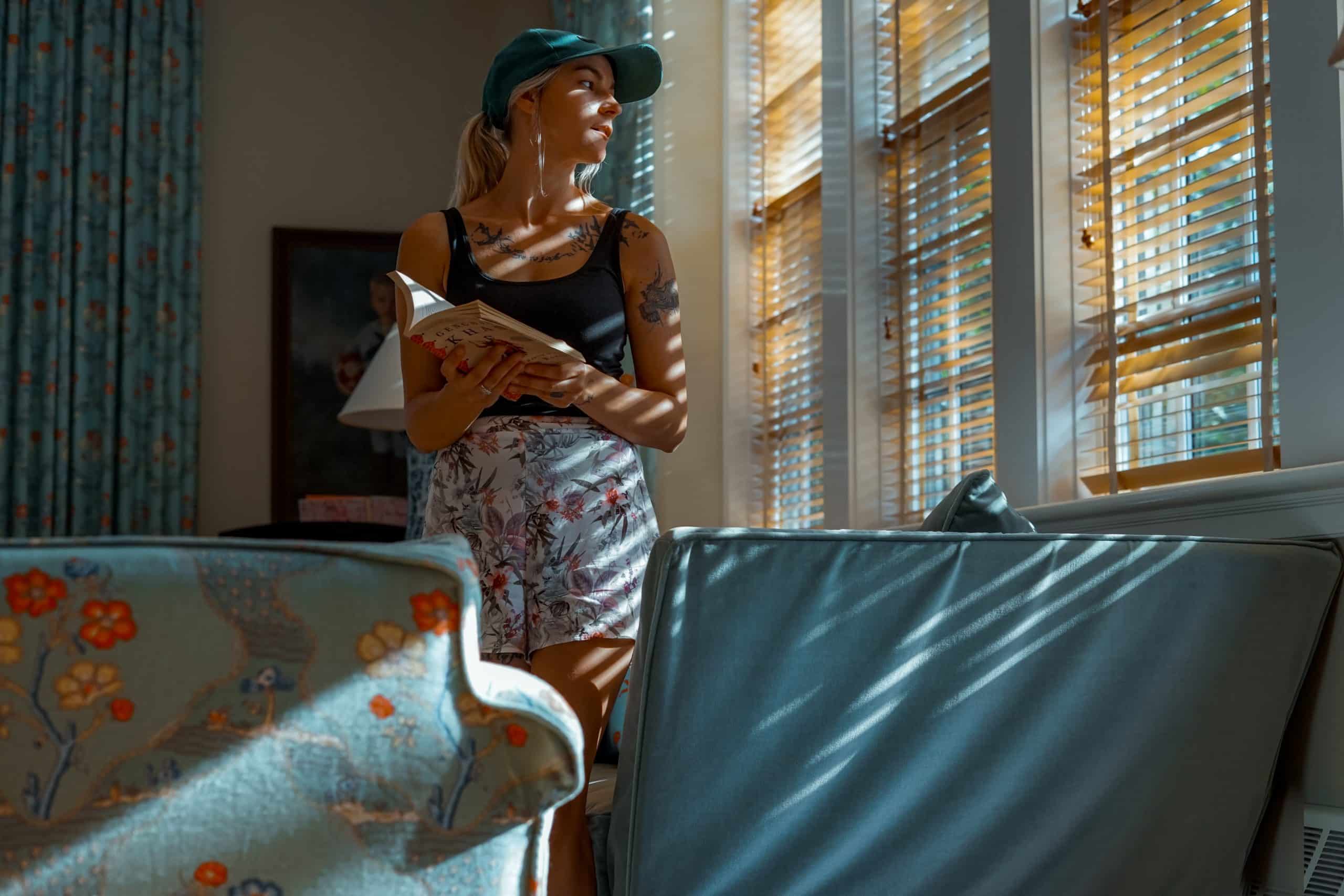 a woman looks out the window of a decorated living room