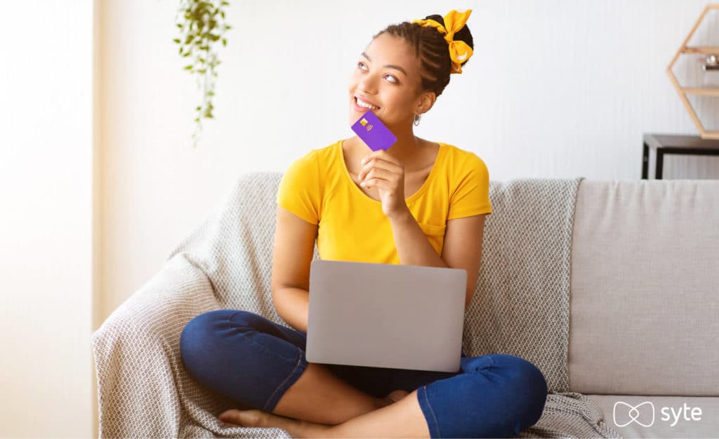 Woman thinking while holding her credit card in her hand. 