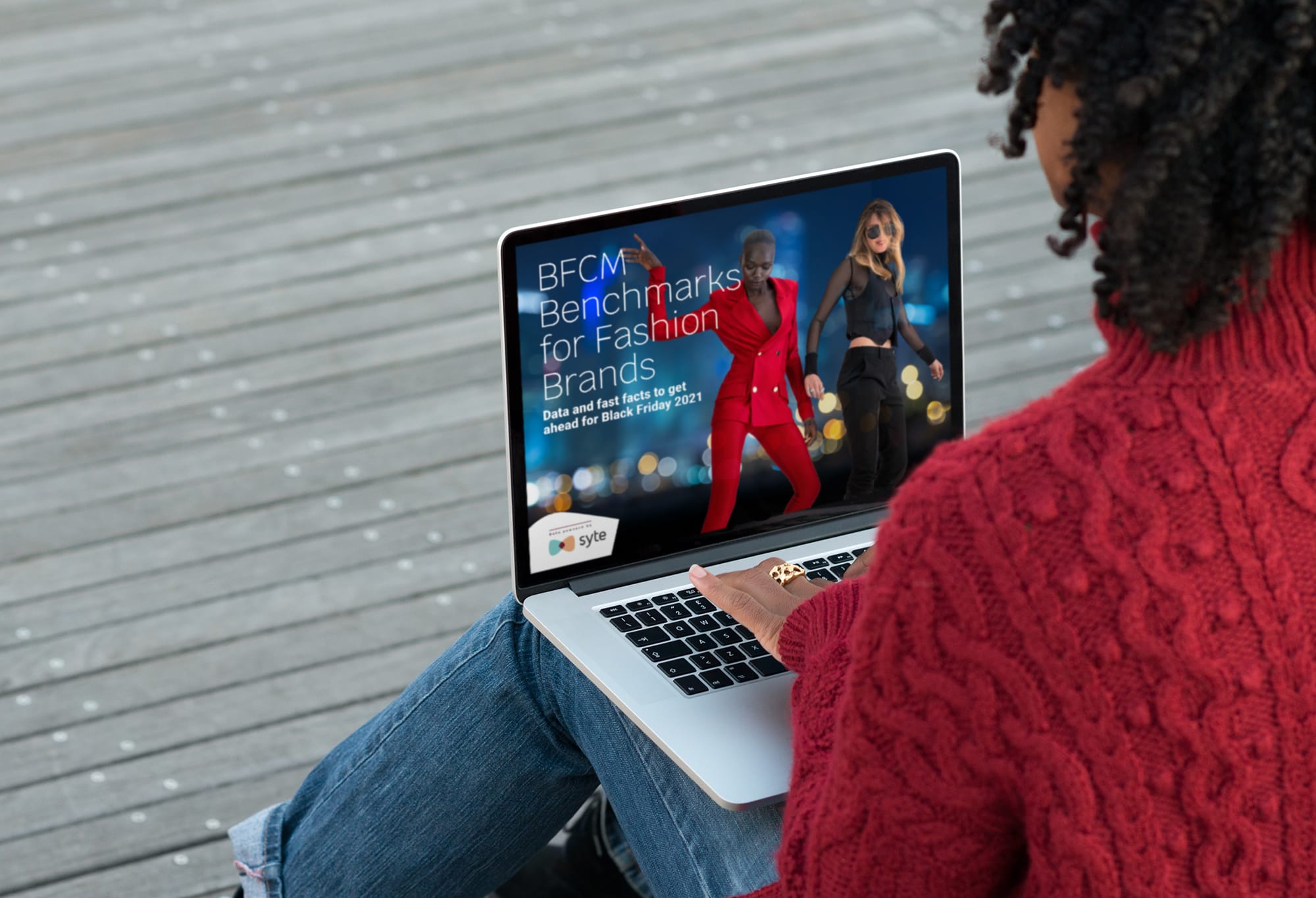 A woman looks at the BFCM fashion report on her laptop