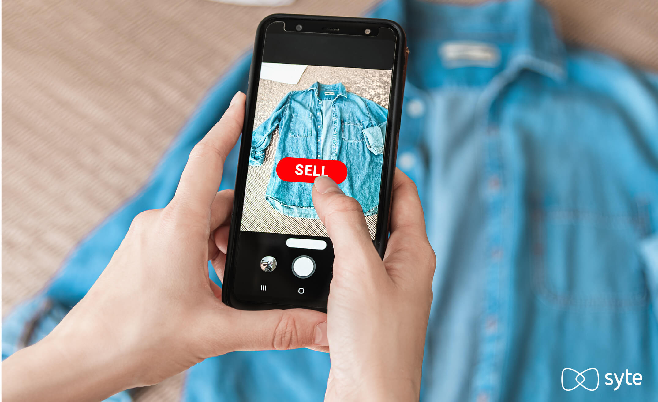 A seller takes a photo of a blue shirt to sell on a resale marketplace