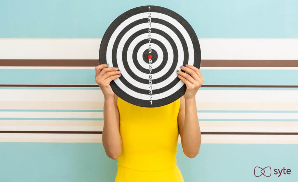 A woman holds up a target represented targeted advertising. 