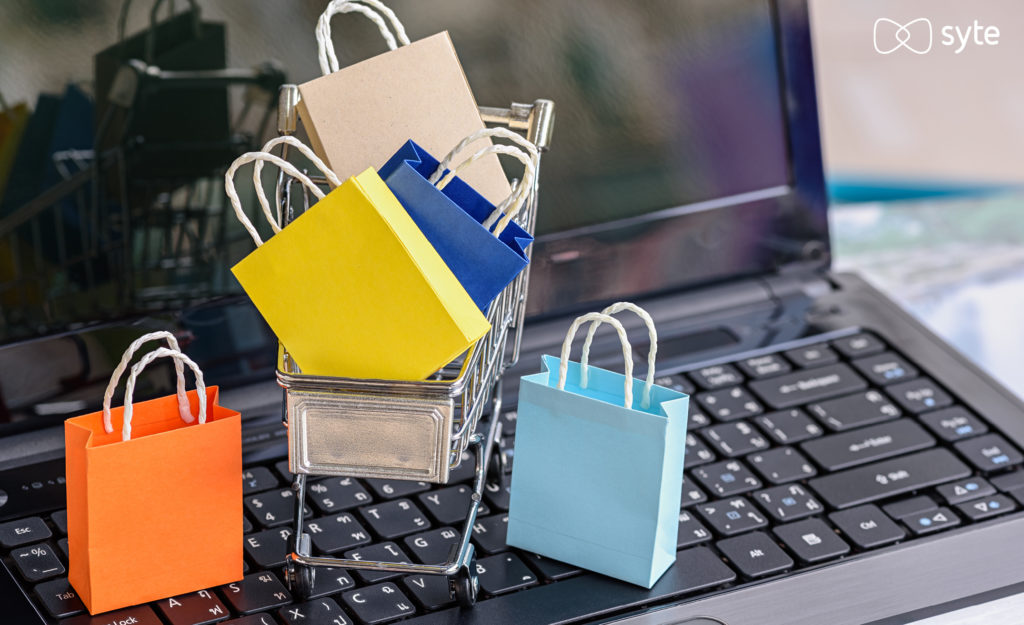 A laptop with a small cart and shopping bags representing eCommerce