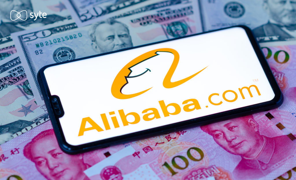 Cell phone with Alibaba website on the screen and paper money in the background