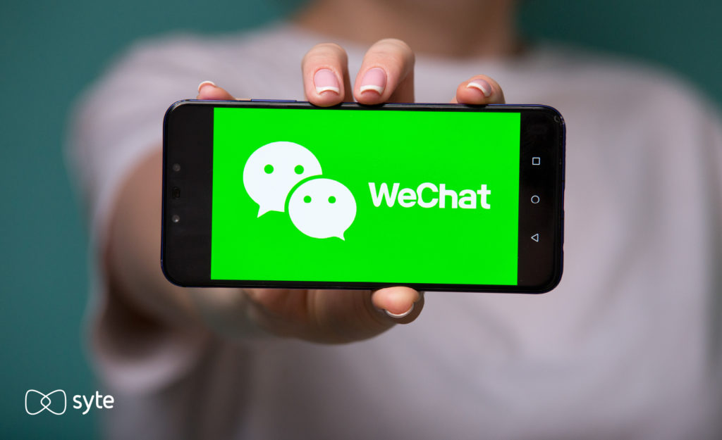 Woman holding her phone out with the WeChat interface open