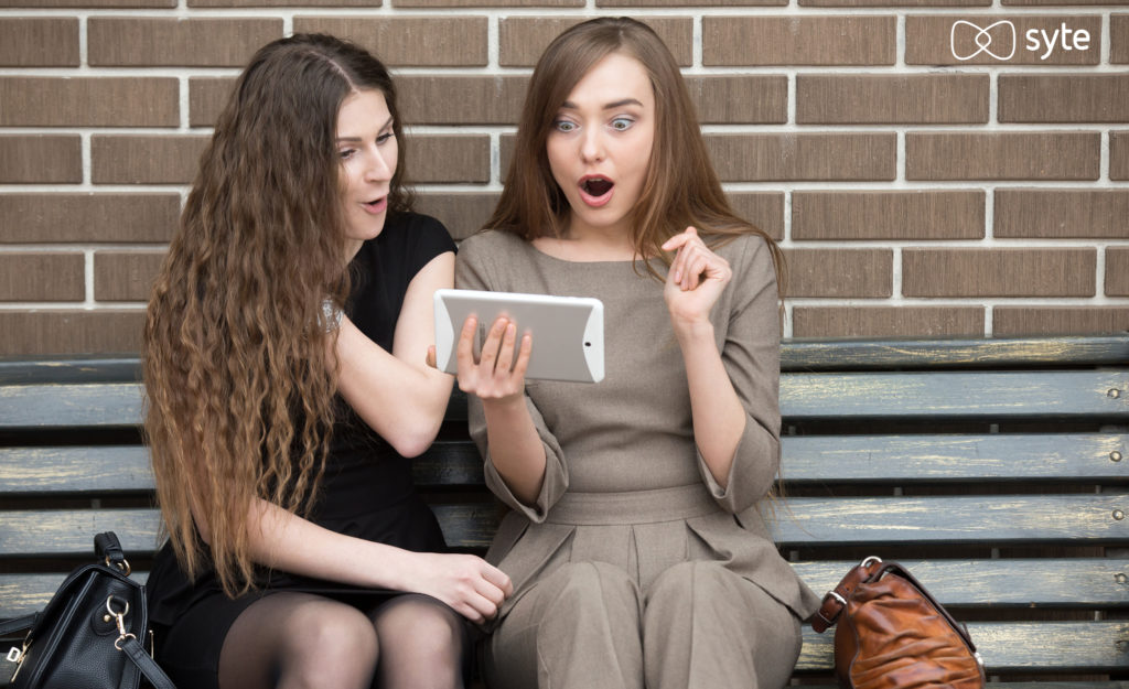 Two women excitedly look at highly relevant site search results. 