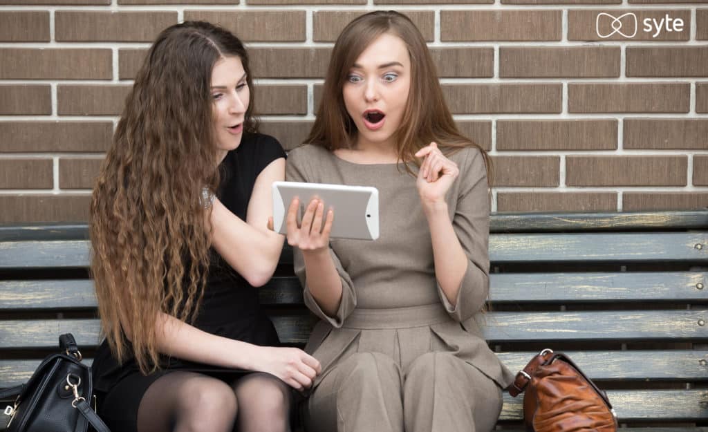 Two women excitedly look at highly relevant site search results.
