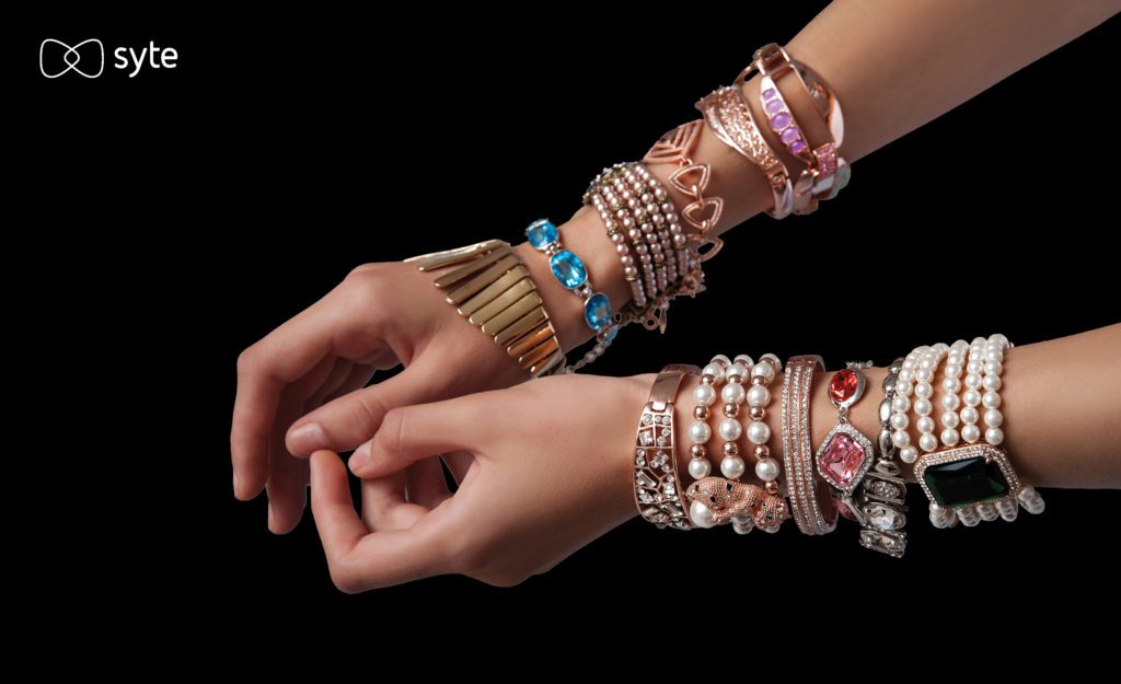 Depiction of a woman's wrists covered in many different bracelets