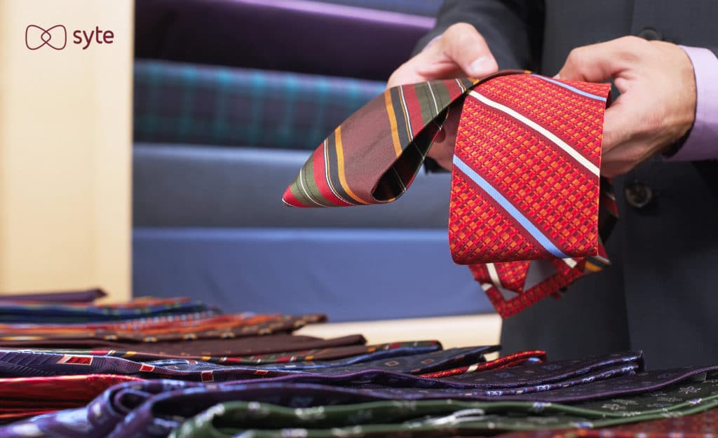 Man choosing between two different ties in a store.