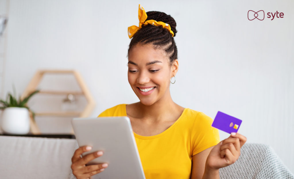 Happy woman shopping online with her credit card in hand.