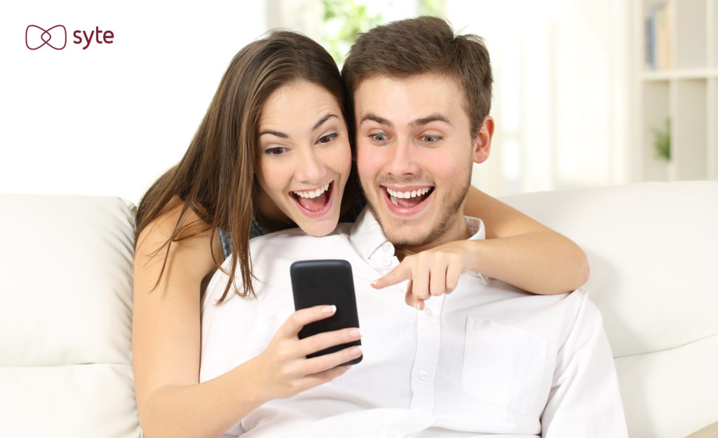 Excited couple looking at iphone 