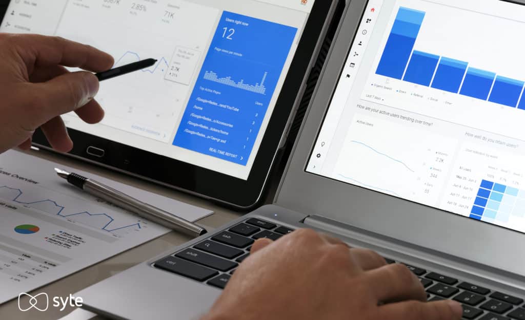 Man analyzes his site search metrics on two computer screens.