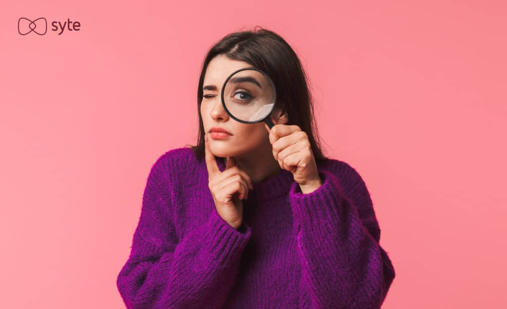 A woman searches using a large magnifying glass. 