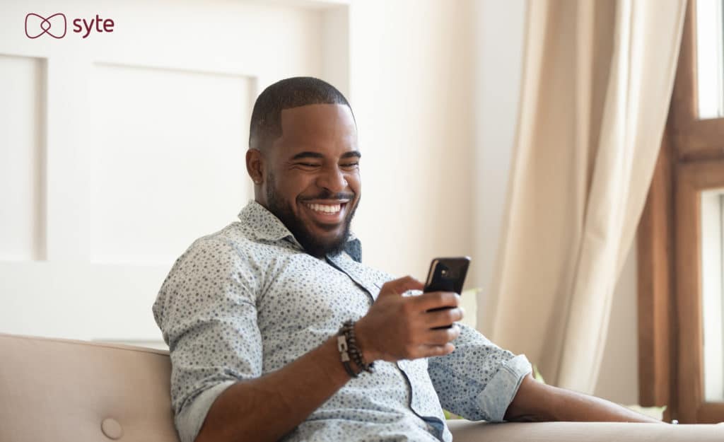 Happy man shopping on his phone demonstrates what healthy customer relationships should look like.