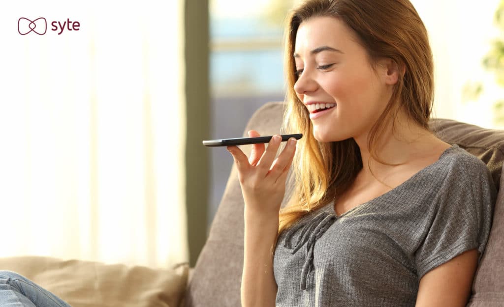 Woman using eCommerce AI to shop with a voice assistant on her phone. 