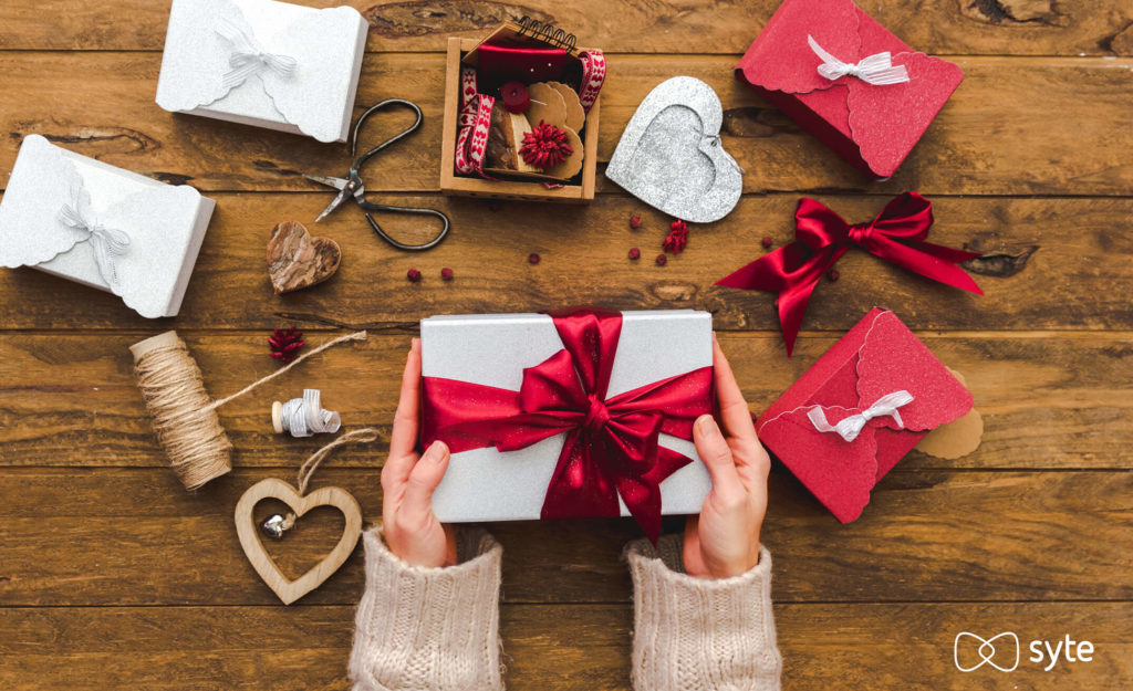 Woman's hands holding a present on a Valentine's Day gift wrapping station