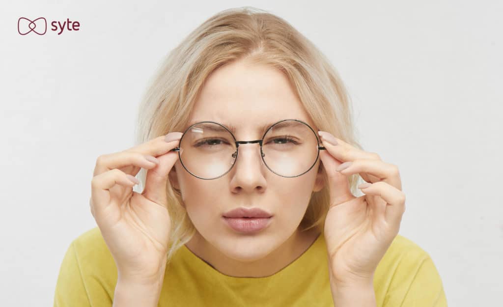 Woman squinting through her glasses, trying to get a closer look