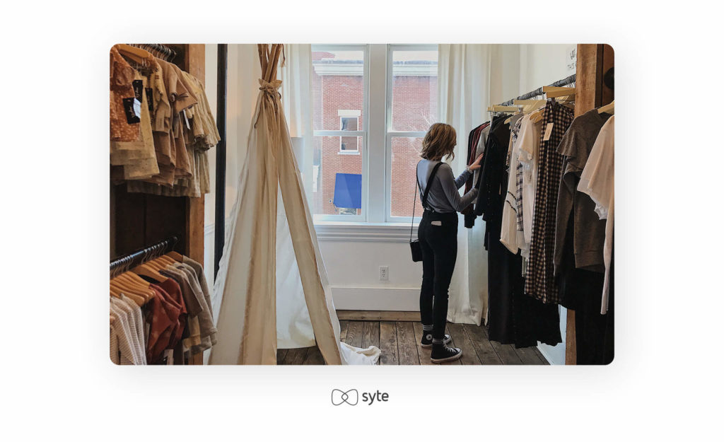 Woman browsing clothing racks in-store