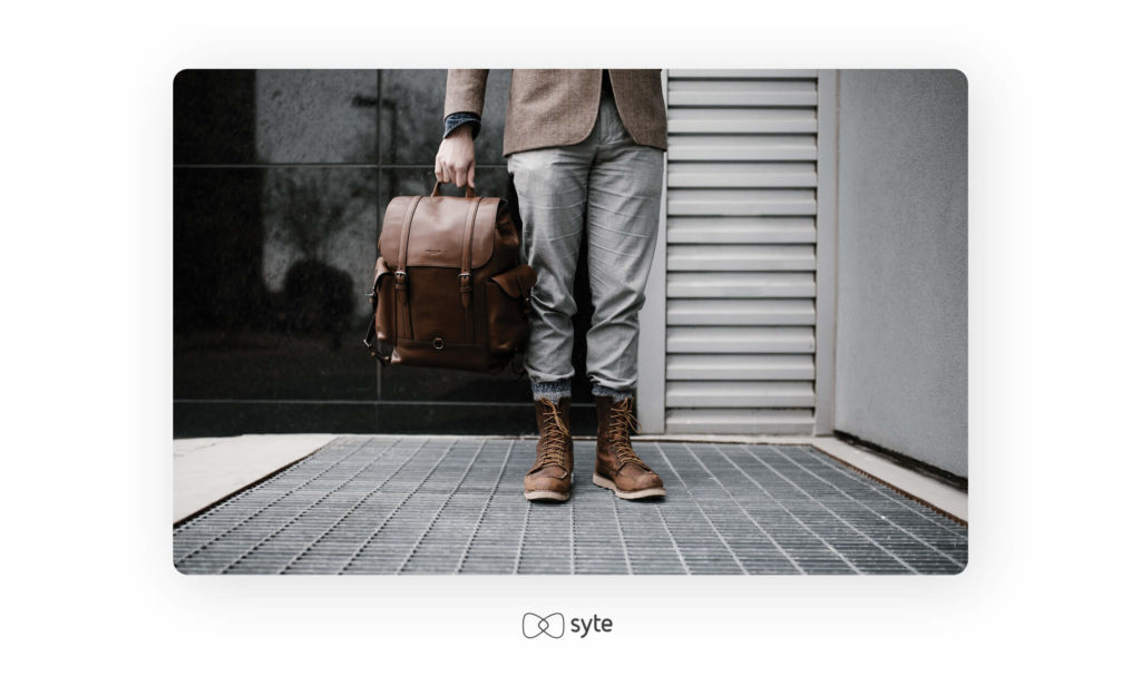 Man standing outside of a shop with a saddle bag