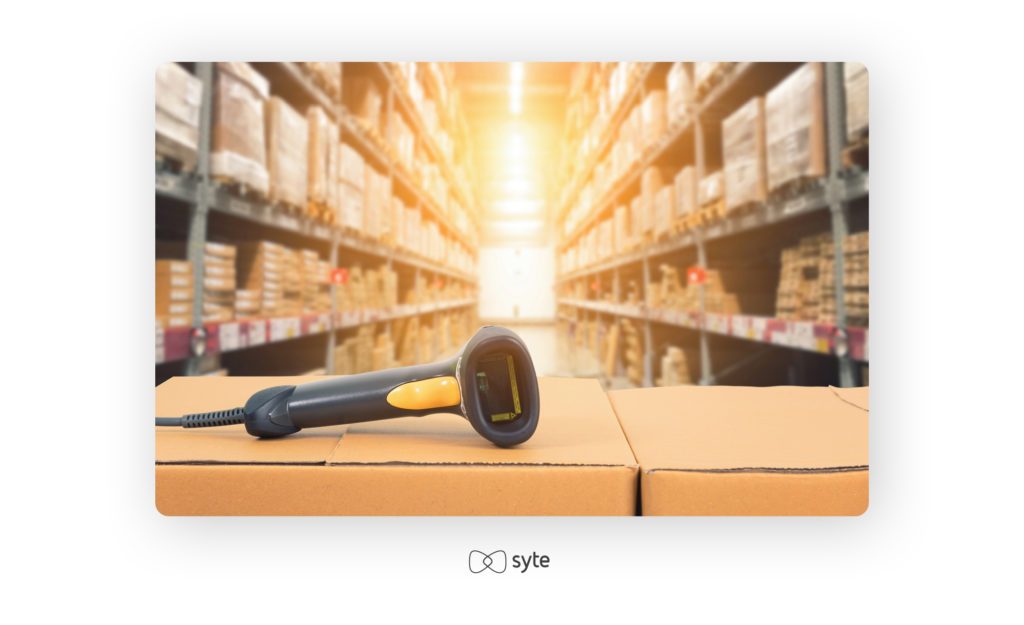 Barcode scanner in front of a modern warehouse.