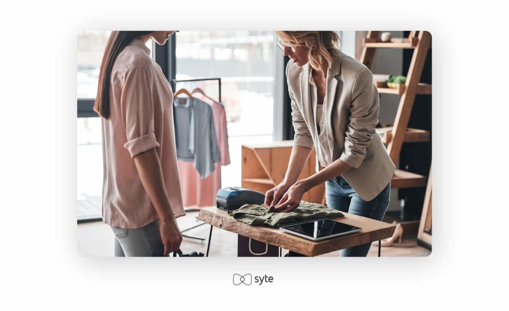 Woman folding a shirt for a customer.