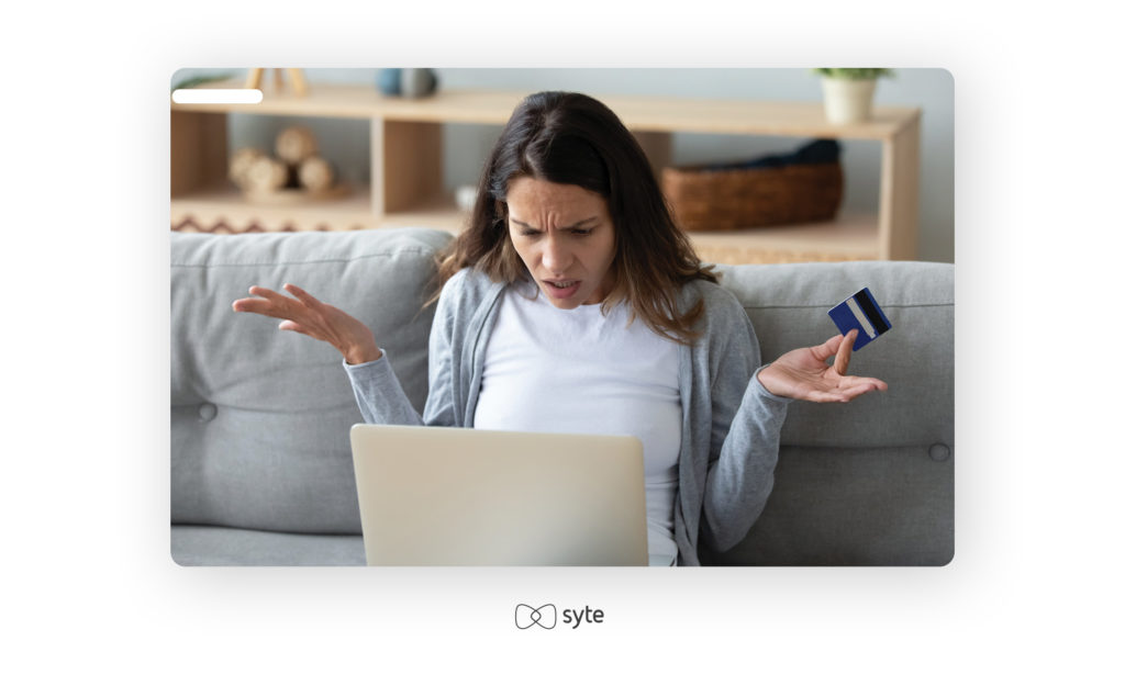 Frustrated female shopper holding credit card and laptop