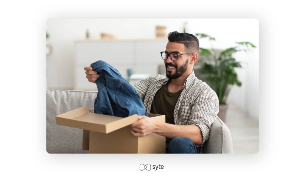 Happy male unboxing his latest ecommerce purchase