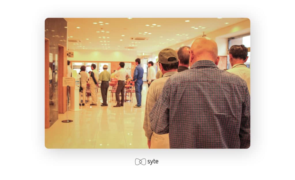 men waiting in long line at store