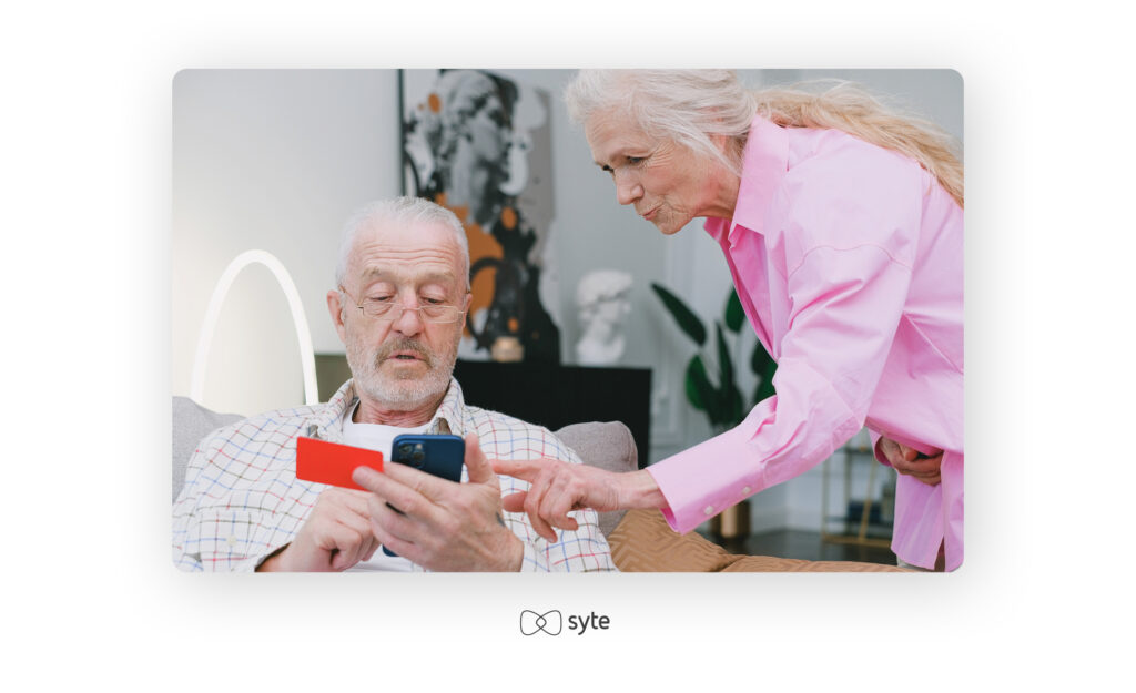 elderly couple using a mobile phone to make an online purchase