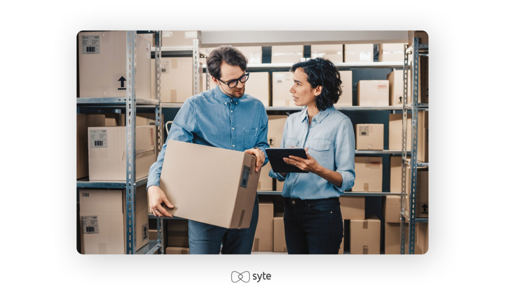 two people in a warehouse looking at inventory so they can make an informed demand forecasting decision