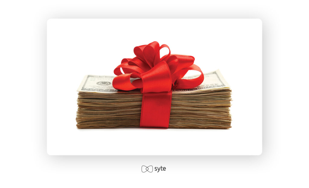 a stack of $100 bills wrapped in a red bow