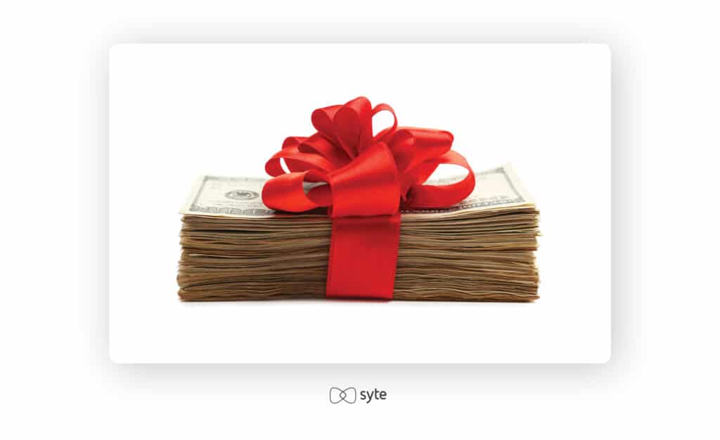 a stack of $100 bills wrapped in a red bow