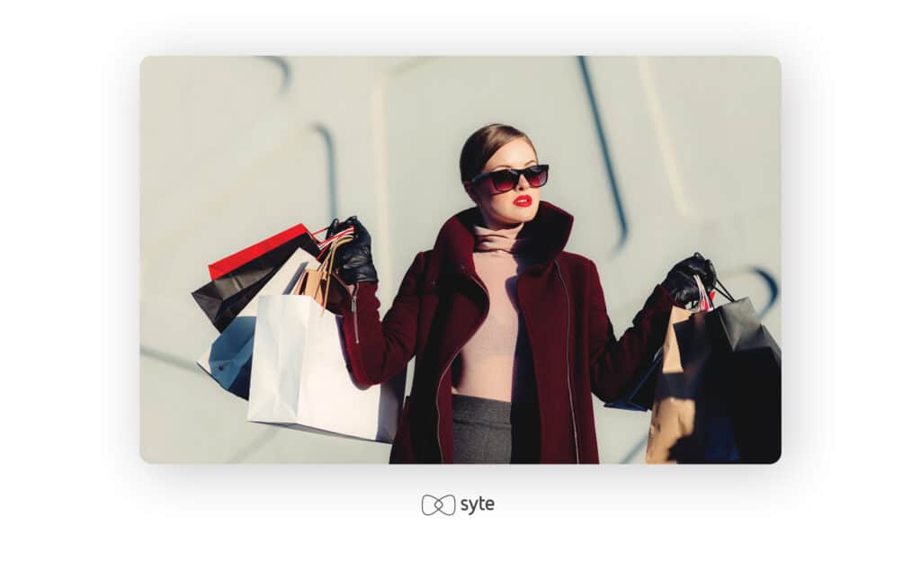 Woman carrying several shopping bags image isolated on yellow studio background