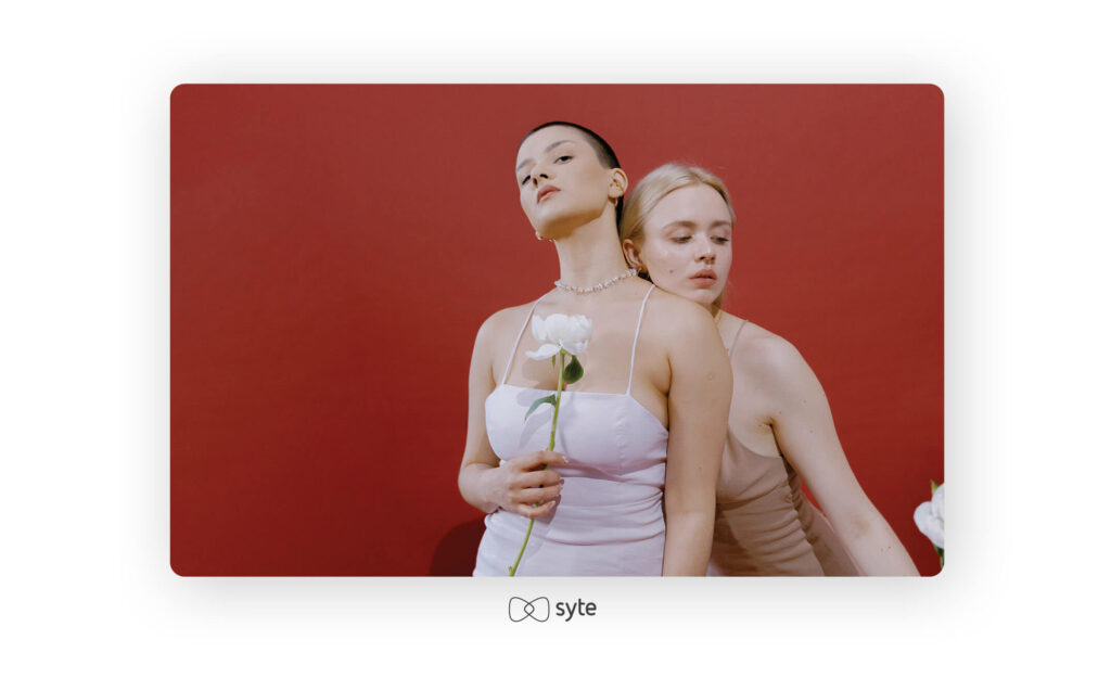 Two girls, one with a white flower in hand.