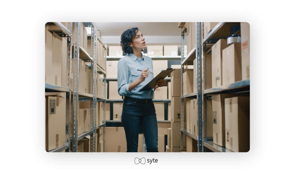 Manager checks stock, writing on her clipboard.